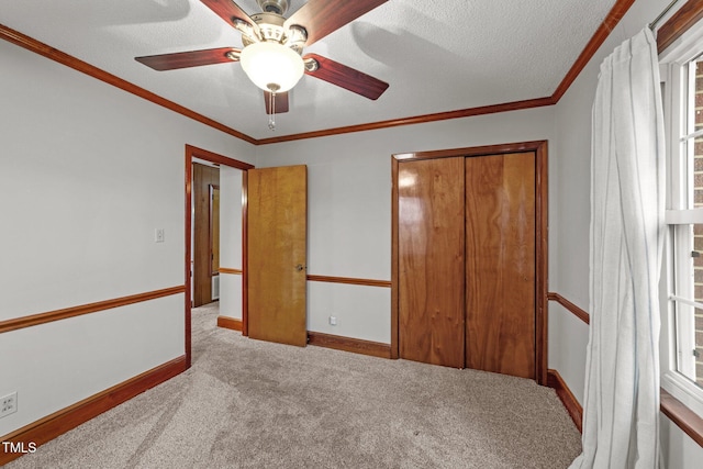 carpeted bedroom featuring multiple windows, ceiling fan, a closet, and ornamental molding