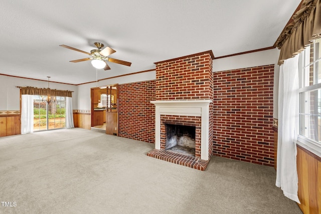 unfurnished living room with wooden walls, brick wall, ceiling fan with notable chandelier, and a brick fireplace