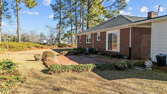 view of property exterior with a lawn, a patio area, and central AC