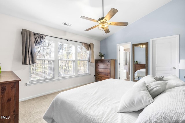 bedroom featuring ensuite bath, ceiling fan, vaulted ceiling, and light colored carpet