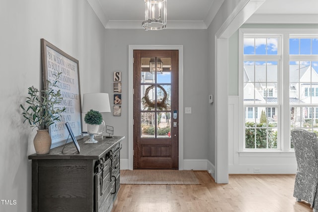 foyer with light wood-type flooring, a wealth of natural light, and crown molding