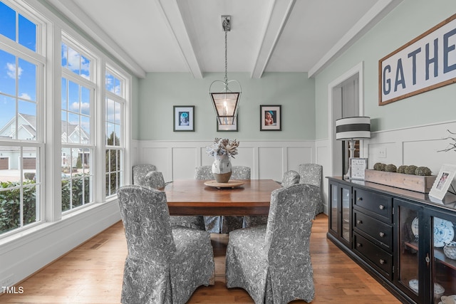 dining room featuring beamed ceiling and hardwood / wood-style floors