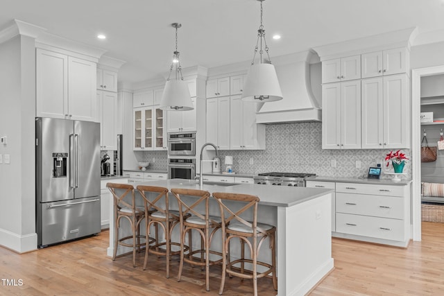 kitchen with a center island with sink, white cabinets, and appliances with stainless steel finishes