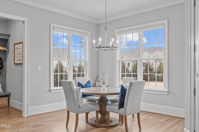 dining room with a notable chandelier, light hardwood / wood-style floors, and crown molding