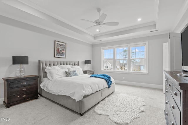 bedroom with ceiling fan, light colored carpet, crown molding, and a tray ceiling