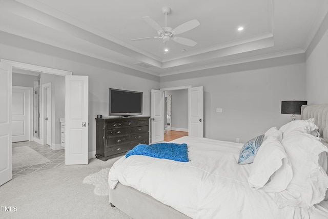 carpeted bedroom with a raised ceiling, ceiling fan, and crown molding