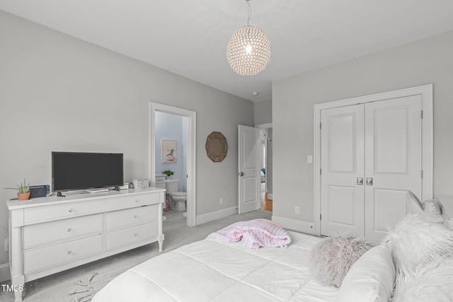 bedroom featuring connected bathroom and light carpet