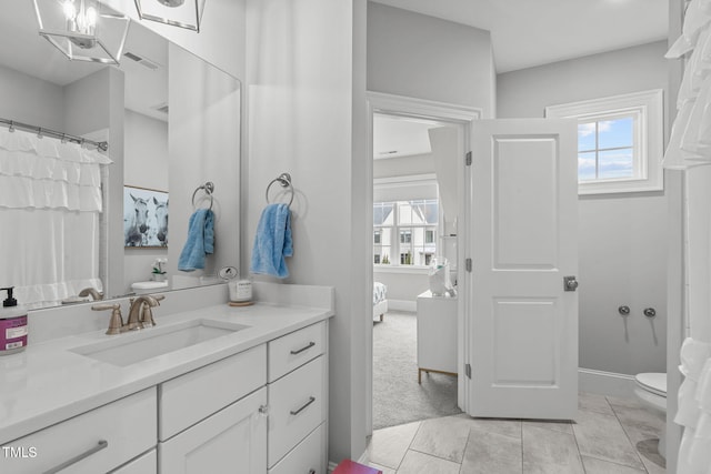 bathroom featuring toilet, vanity, and tile patterned flooring