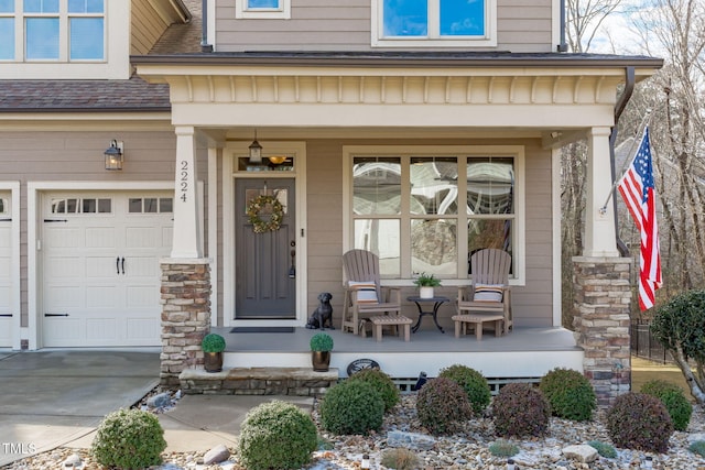 doorway to property with a garage and covered porch