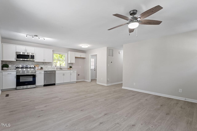 kitchen featuring white cabinets, light wood-type flooring, stainless steel appliances, and sink