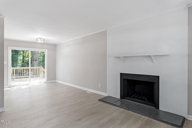 unfurnished living room featuring crown molding and hardwood / wood-style floors