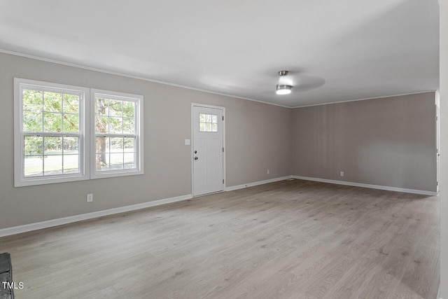 interior space featuring ceiling fan, plenty of natural light, ornamental molding, and light wood-type flooring