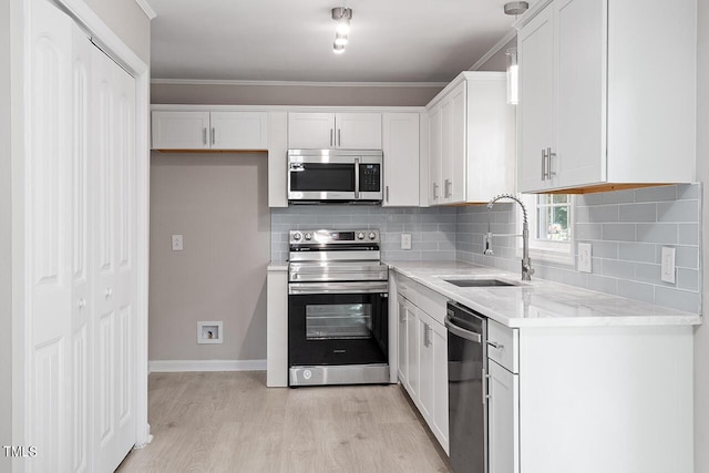 kitchen with appliances with stainless steel finishes, white cabinetry, and sink