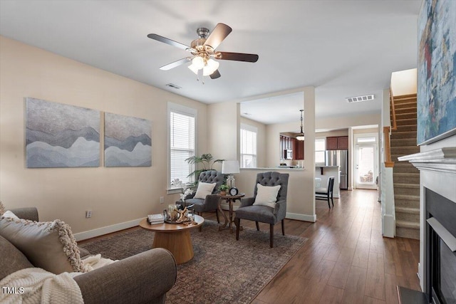 living room with ceiling fan, dark wood-type flooring, and a wealth of natural light