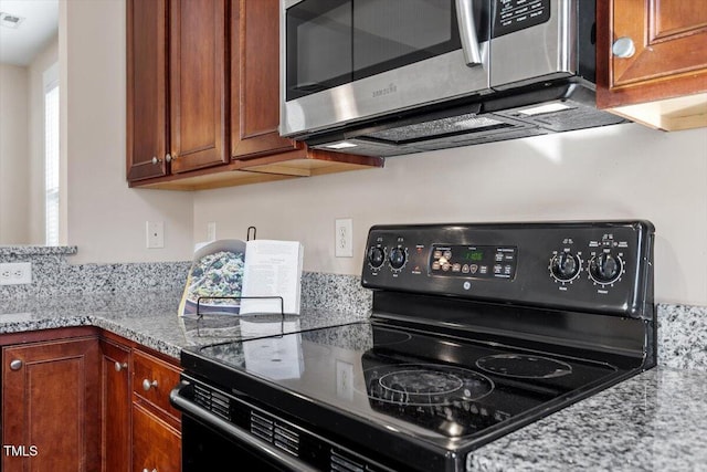 kitchen with light stone counters and black electric range oven