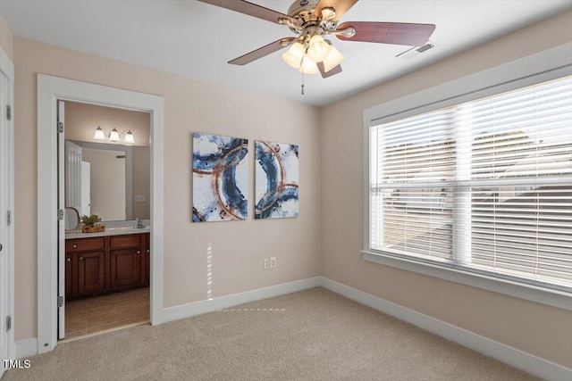 interior space with ceiling fan, sink, and connected bathroom