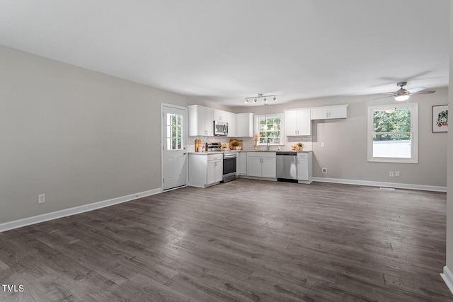 unfurnished living room featuring dark hardwood / wood-style flooring, a wealth of natural light, and sink