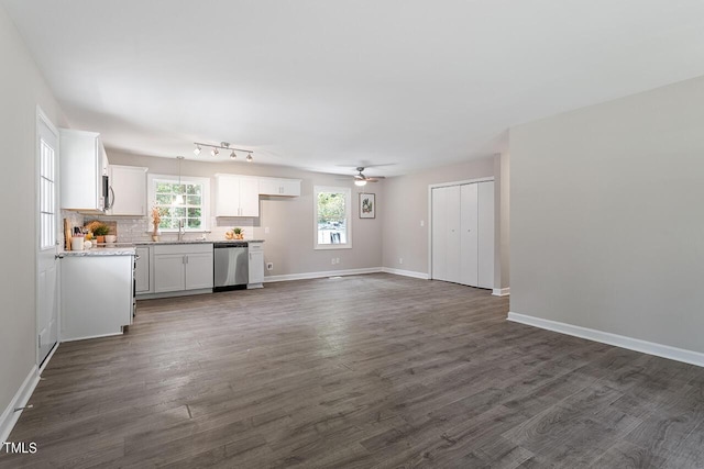 unfurnished living room featuring ceiling fan, dark hardwood / wood-style flooring, and sink