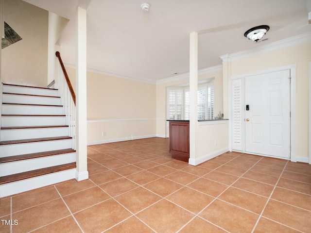 entrance foyer with crown molding and tile patterned flooring