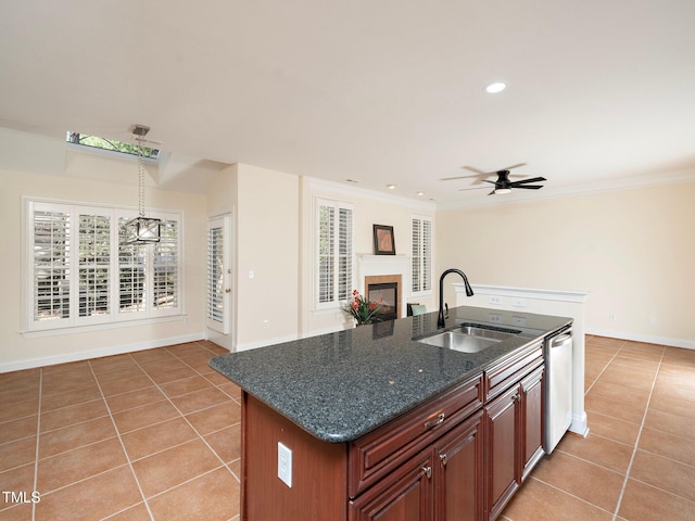 kitchen with sink, light tile patterned floors, stainless steel dishwasher, and an island with sink