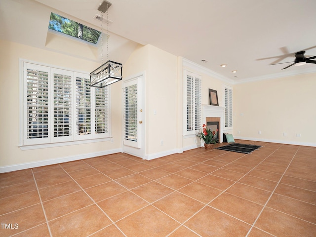 unfurnished living room featuring crown molding, tile patterned floors, and ceiling fan with notable chandelier