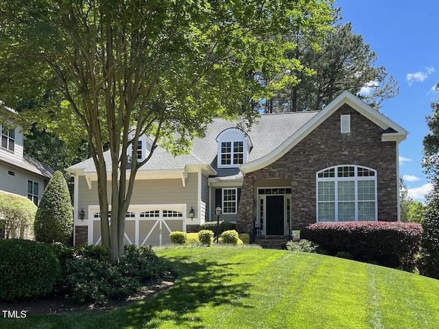 view of front of home with a garage, a front yard, and stone siding