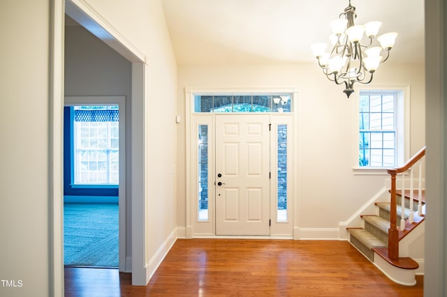 foyer featuring stairway, baseboards, a notable chandelier, and wood finished floors