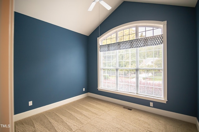 carpeted empty room with vaulted ceiling, baseboards, visible vents, and ceiling fan