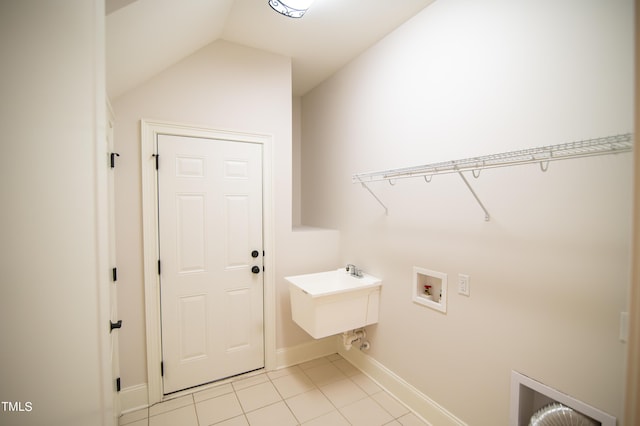 laundry area with light tile patterned floors, baseboards, laundry area, a sink, and washer hookup