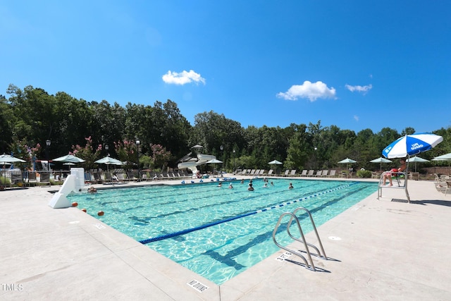 community pool with a patio and fence