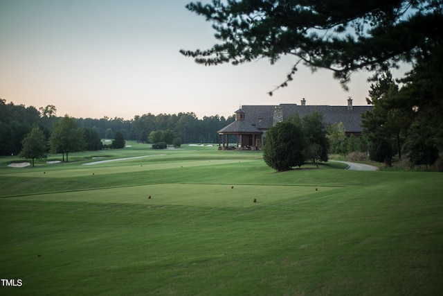 view of community with view of golf course and a yard