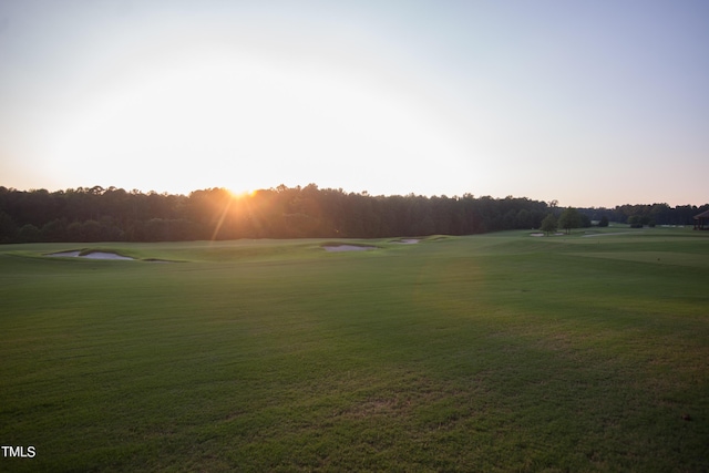 view of community featuring view of golf course and a lawn