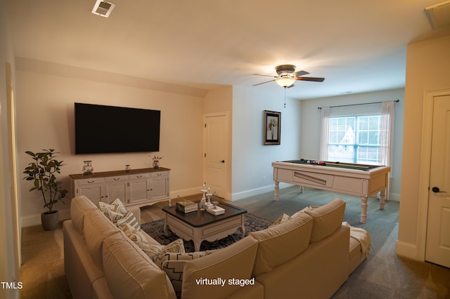 carpeted living room with visible vents, baseboards, and a ceiling fan