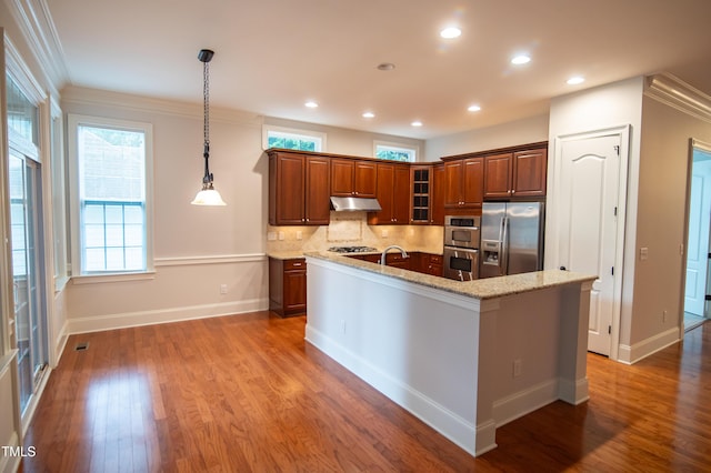 kitchen featuring glass insert cabinets, light stone countertops, decorative backsplash, wood finished floors, and stainless steel appliances