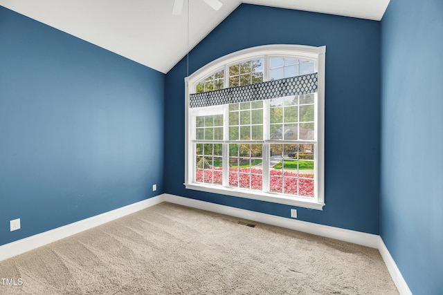 carpeted spare room featuring visible vents, baseboards, ceiling fan, and vaulted ceiling