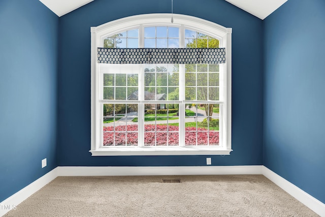 unfurnished room with visible vents, a wealth of natural light, carpet, and baseboards
