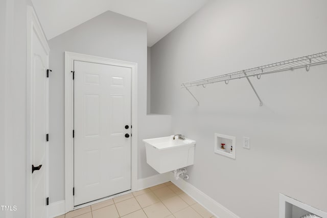laundry area featuring baseboards, light tile patterned floors, laundry area, hookup for a washing machine, and a sink