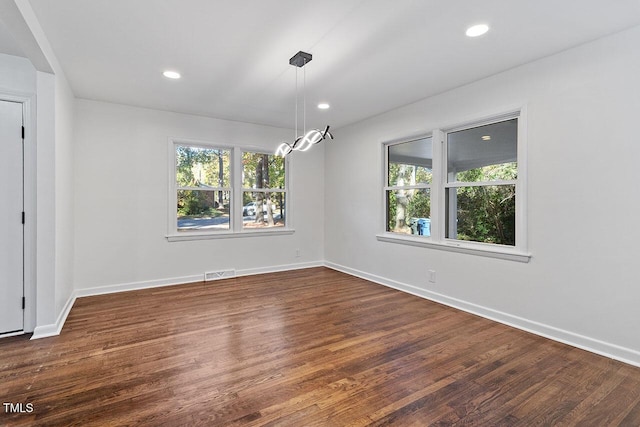 unfurnished dining area with dark hardwood / wood-style flooring and plenty of natural light