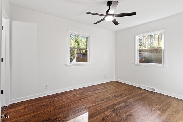 unfurnished room with ceiling fan and dark wood-type flooring