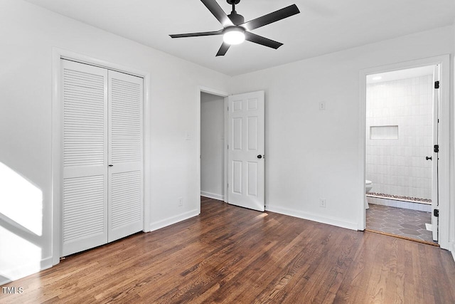 unfurnished bedroom featuring ensuite bath, ceiling fan, a closet, and dark wood-type flooring