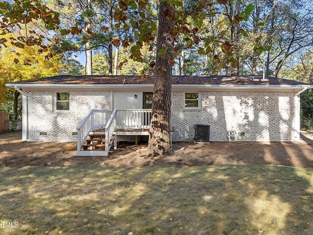 back of property with a yard, central AC unit, and a wooden deck