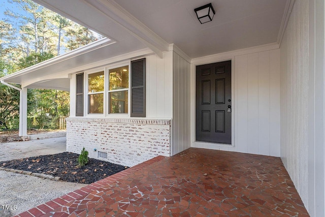 view of exterior entry featuring covered porch