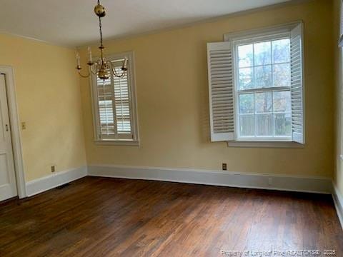 unfurnished dining area with a chandelier and dark hardwood / wood-style flooring