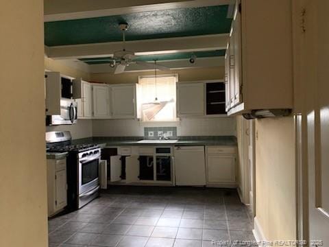 kitchen featuring appliances with stainless steel finishes, white cabinetry, ceiling fan, and sink