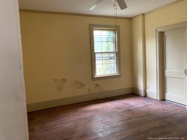 empty room with ceiling fan, hardwood / wood-style floors, and ornamental molding