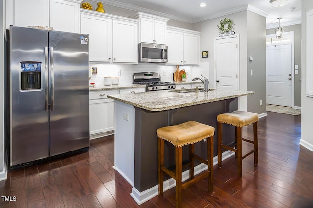 kitchen featuring white cabinetry, sink, light stone countertops, a center island with sink, and appliances with stainless steel finishes