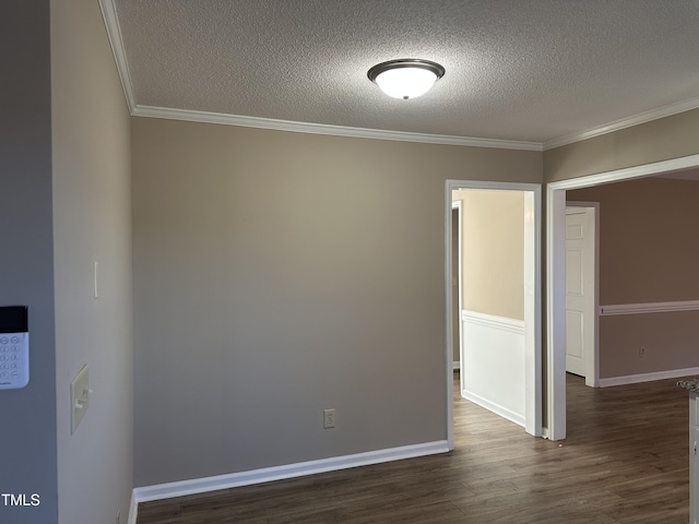 empty room with a textured ceiling, crown molding, and dark wood-type flooring