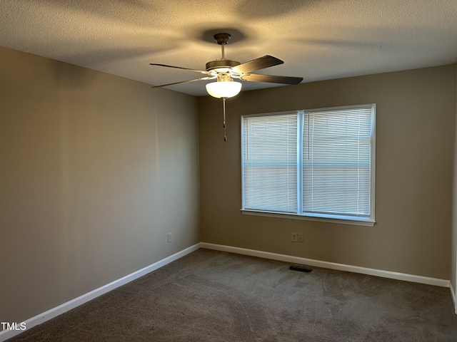 carpeted empty room featuring ceiling fan and a textured ceiling