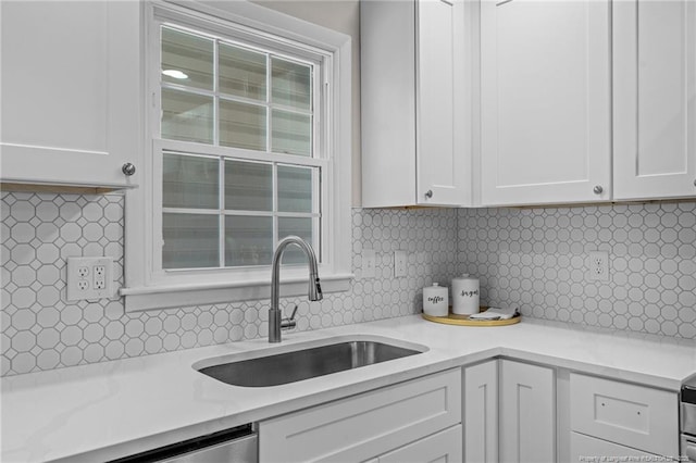 kitchen featuring white cabinets, tasteful backsplash, and sink