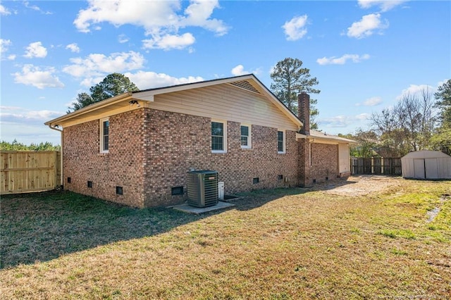 view of home's exterior featuring central AC unit, a storage unit, and a yard